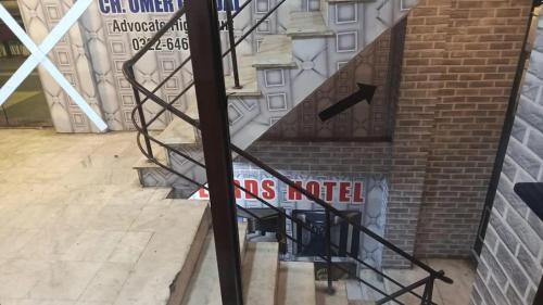 a staircase with a sign on the side of a building at The Lords Hotel in Lahore