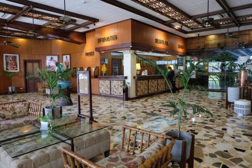 a lobby of a hotel with tables and plants at Oasis Hotel in Angeles