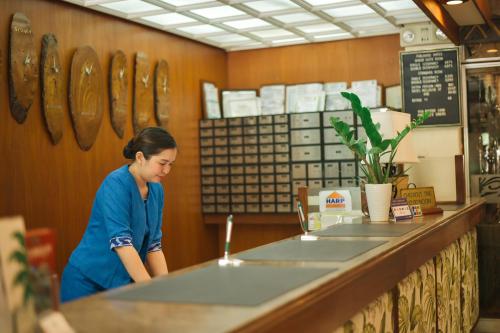 a woman standing at the counter of a restaurant at Oasis Hotel in Angeles