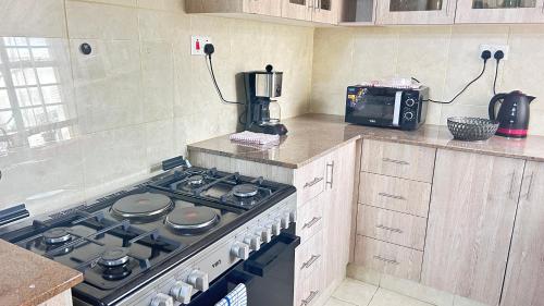a kitchen with a stove and a coffee maker at Regal Suites in Athi River