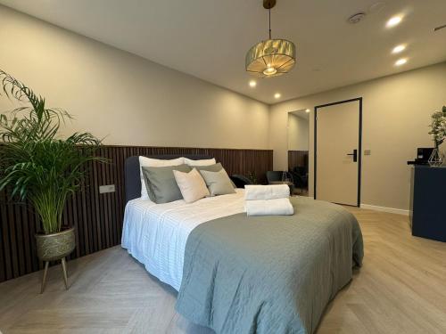 a bedroom with a large bed and a potted plant at The Stylish Gem of Den Haag Aprt R1 in The Hague