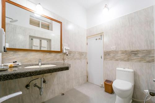 a bathroom with a sink and a toilet and a mirror at Hotel Chandrawati Palace in Ābu Road