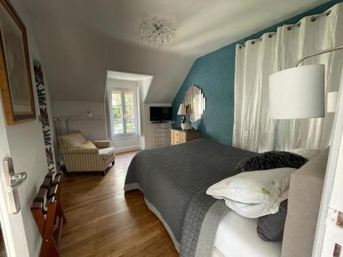 a bedroom with a bed and a blue wall at Chambres et Tables d'hôtes du Puits d'Athie in Appoigny