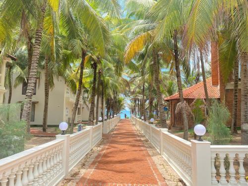 a bridge in front of a resort with palm trees at Kega Lighthouse Beach Resort in Ke Ga