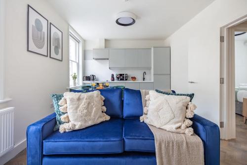 a blue couch with pillows in a living room at BnBNova - 1BR - St Paul's & Barbican in London