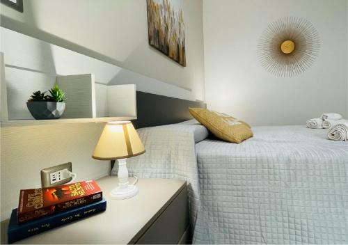a bedroom with two beds and a lamp on a night stand at La Collina di Montegrappa - Suites with Heated Private Pool - Suites with Shared Pool in Tuglie
