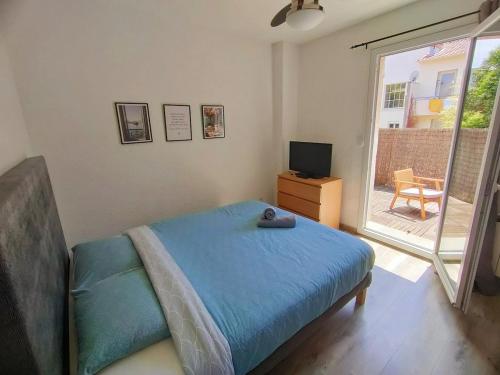 une chambre avec un lit, une télévision et une fenêtre dans l'établissement AZEMA : Cocon tranquille avec terrasse proche du centre, à Montpellier