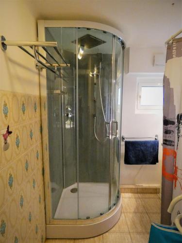 une douche avec une porte vitrée dans une salle de bain dans l'établissement Gite LEGRAND, à Prades