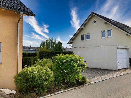 a white house with a garage and some bushes at 3 Zimmer Apartment, 110 qm, max 5 Personen, Balkon, Parkplatz, Internet 250 MBit in Gärtringen