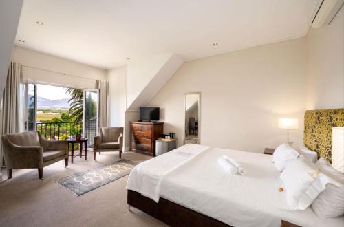 a bedroom with a large bed and a balcony at Wild Mushroom Country House in Stellenbosch