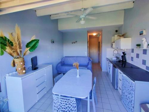 - une cuisine avec une table et un canapé dans une chambre dans l'établissement RESIDENCE DU GOLF : Détente, confort et loisirs à deux pas de la plage, au Cap d'Agde