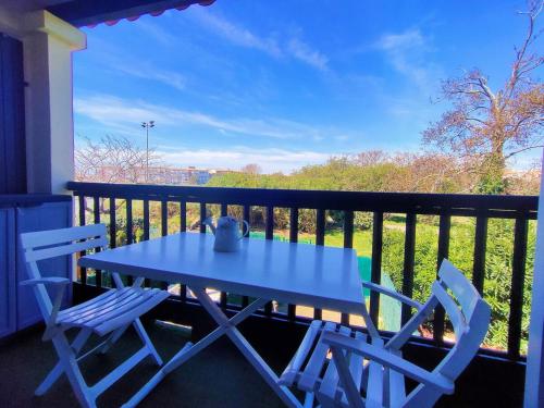 une table bleue et deux chaises sur un balcon dans l'établissement RESIDENCE DU GOLF : Détente, confort et loisirs à deux pas de la plage, au Cap d'Agde