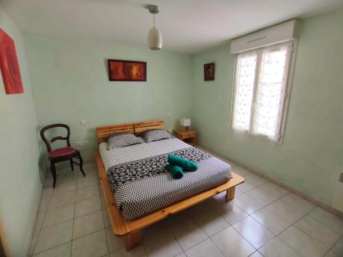 une chambre avec un lit, une chaise et une fenêtre dans l'établissement Havre de paix au cœur du village de Florensac., à Florensac