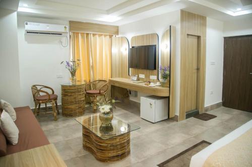 a living room with a table and a desk at Hotel Lake Shilloi in Dimāpur