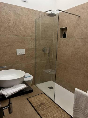 a bathroom with a shower with a toilet and a sink at Bien-être Exclusive Apartment in Taranto
