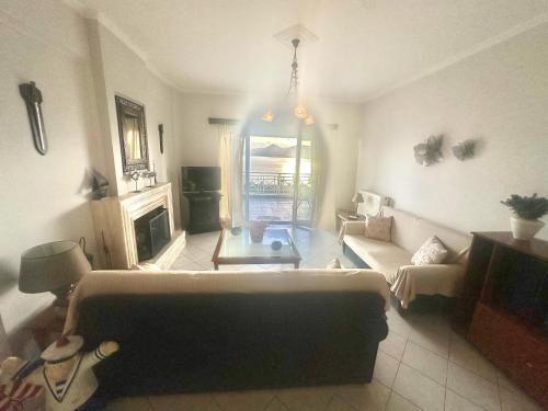a living room with a couch and a table at VillaSunset in Paleros
