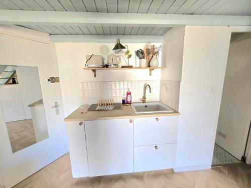 une cuisine avec des armoires blanches et un évier dans l'établissement CABANEL : Nid douillet perché en plein centre historique, à Montpellier