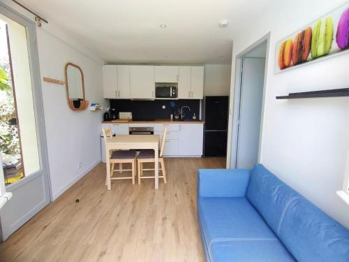un salon avec un canapé bleu et une cuisine dans l'établissement Une Oasis de détente, un cocon avec piscine privée., à Marseillan