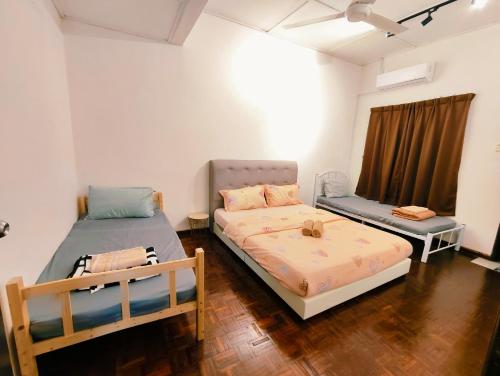 a room with two beds and a window at Area Indahpura or Taman Bersatu Kulai 3-4BR near AEON Airport JPO in Kulai