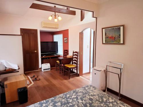 a room with a bed and a desk and a television at ローズウッドガーデンアンドヴィラ in Nasu