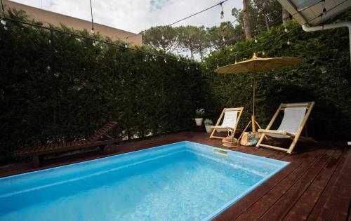 a swimming pool with two chairs and an umbrella at Ingrit Gjoni Villas in Draçi