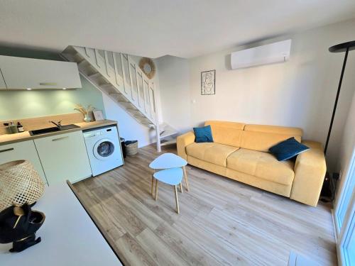 un salon avec un canapé et une cuisine dans l'établissement Les Ondins : Résidence avec piscine, jardin, proche de la plage, à Marseillan