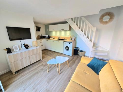 un salon avec un canapé et une cuisine dans l'établissement Les Ondins : Résidence avec piscine, jardin, proche de la plage, à Marseillan