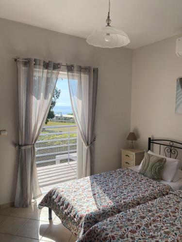 斯卡拉Villa Elizabeth的一间卧室，里面有一张床和一扇大窗户。