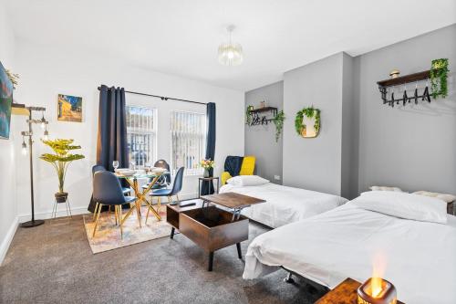 a bedroom with two beds and a table and chairs at Stylish Birmingham Apartment For Groups, Family & Work in Birmingham