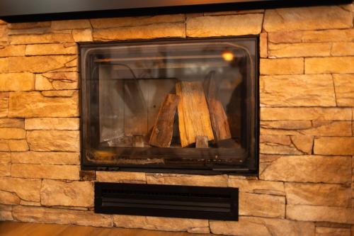a stone fireplace with wooden logs in it at Ingrit Gjoni Villas in Draçi