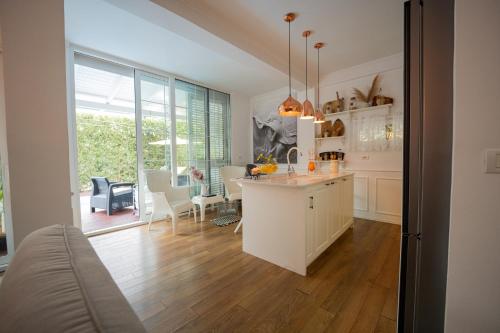 a kitchen with white cabinets and a dining room at Ingrit Gjoni Villas in Draçi