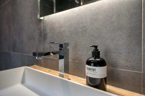 a bathroom with a bottle of mouthwash on a sink at Heliantheme, The Lofty Penthouse in Champéry