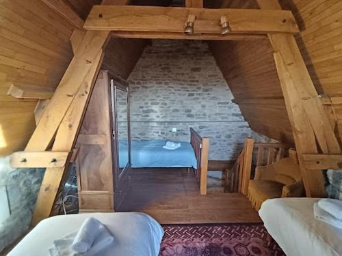 Cette chambre mansardée comprend deux lits et un escalier. dans l'établissement Maison près de Sarlat, à Sarlat-la-Canéda