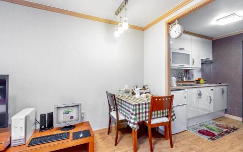 a kitchen with a table and a desk with a computer at Spa Pension Basso in Sokcho