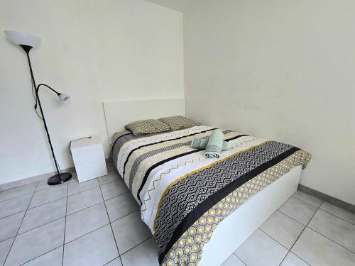 - une chambre avec un lit et une lampe dans l'établissement ACADIE : Studio quartier Antigone, ascenseur tramway calme, à Montpellier
