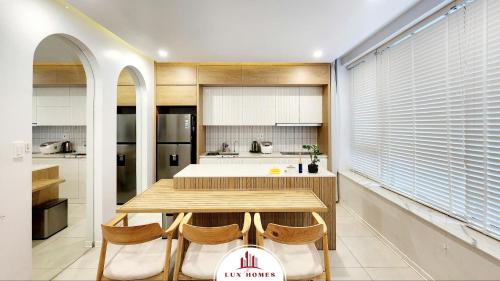 a kitchen with a wooden table and some chairs at The LuxHomes Apartment ᵀᴹ I HOT Độc Đáo Nhất Vinhomes Marina in Hai Phong