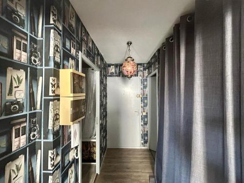 un couloir avec des photos sur les murs et un lustre dans l'établissement POLYNICE : Studio atypique avec terrasse au cœur d'Antigone, à Montpellier