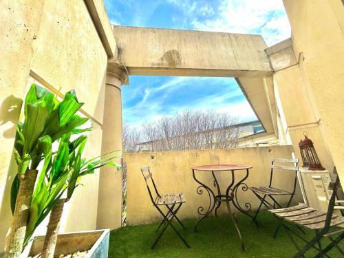 un patio avec une table et des chaises sur un balcon dans l'établissement POLYNICE : Studio atypique avec terrasse au cœur d'Antigone, à Montpellier