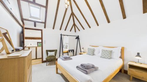a bedroom with a bed and a desk at The Cote is a stunning rural barn beach 3 miles in Haven Street