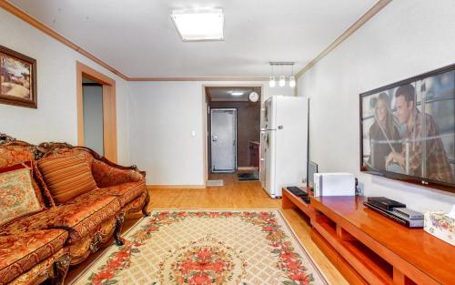 a living room with a couch and a table at Spa Pension Basso in Sokcho