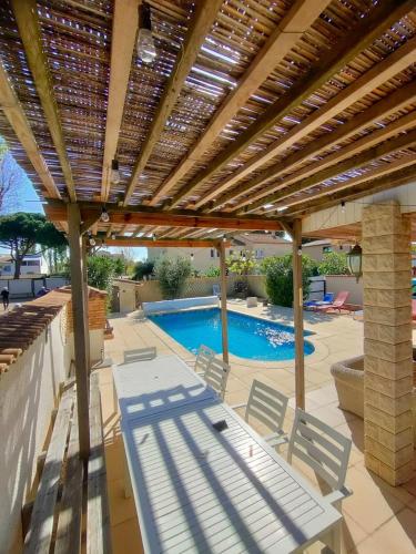 un patio avec deux chaises et une piscine dans l'établissement LA VILLA du GRAU D'AGDE : Le rêve : Détente, plage et gastronomie, au Grau-dʼAgde