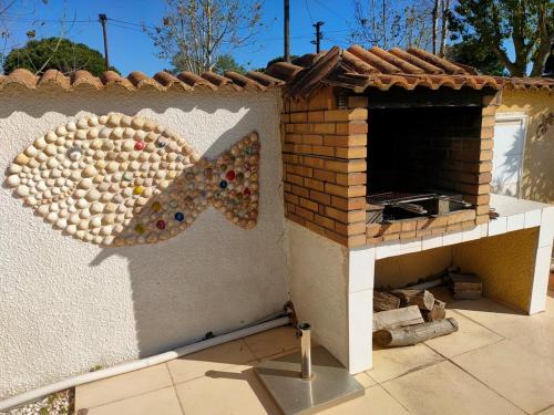 - un four à pizza sur le côté d'une maison dans l'établissement LA VILLA du GRAU D'AGDE : Le rêve : Détente, plage et gastronomie, au Grau-dʼAgde