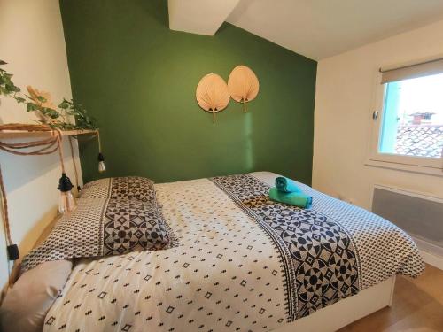 Ce lit se trouve dans une chambre dotée d'un mur vert. dans l'établissement BARNABE : Nid douillet perché en plein centre historique., à Montpellier