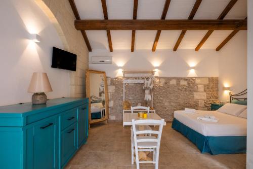 a bedroom with a bed and a table and chairs at Agriturismo Alonì Costarella Masseria in Borgagne