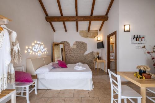 a bedroom with a bed and a table and chairs at Agriturismo Alonì Costarella Masseria in Borgagne