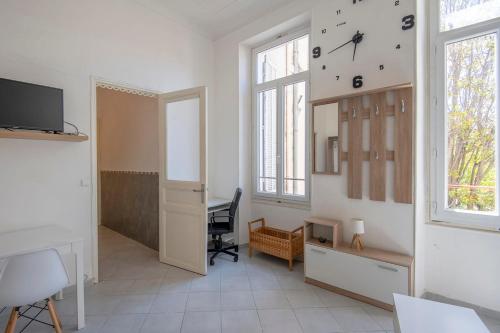 Cette chambre dispose d'un bureau et d'une horloge murale. dans l'établissement Bright studio near the old port - Marseille, à Marseille
