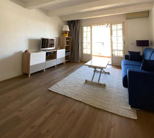 un salon avec un canapé bleu et une table dans l'établissement Emeraude, à Saint-Raphaël