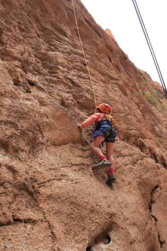 a young girl climbing on a rock wall at Kasbah Maison D’hôte Lalla Zahra in Aït Baha