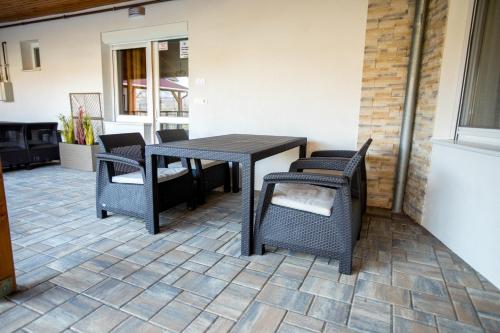 a table and chairs sitting on a patio at Mátravölgy Apartmanház in Pásztó