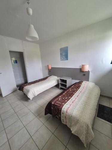 - une chambre avec deux lits et du carrelage dans l'établissement Motel le Bon Samaritain, à Roucy